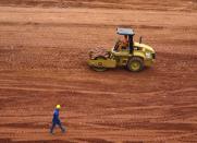 A workman rolls out dirt for the pitch inside the Arena da Baixada stadium as work continues in preparation for the 2014 FIFA World Cup soccer championship in Curitiba December 11, 2013. The 2014 World Cup finals will be held in Brazil from June 12 through July 13. REUTERS/Gary Hershorn (BRAZIL - Tags: SPORT SOCCER WORLD CUP)