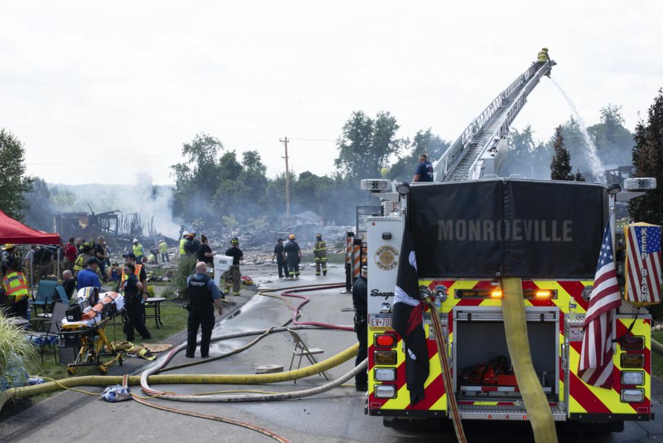 Police and emergency services control the smoldering debris of the three houses that exploded near Rustic Ridge Drive and Brookside Drive in Plum, Pa., on Saturday, Aug. 12, 2023. (Samuel Long/Pittsburgh Post-Gazette via AP/Pittsburgh Post-Gazette via AP)