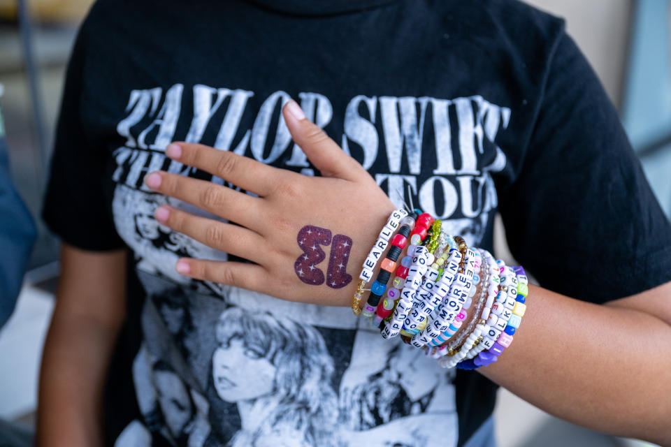 A Taylor Swift fan, friendship bracelet detail, attends the opening night theatrical release of 