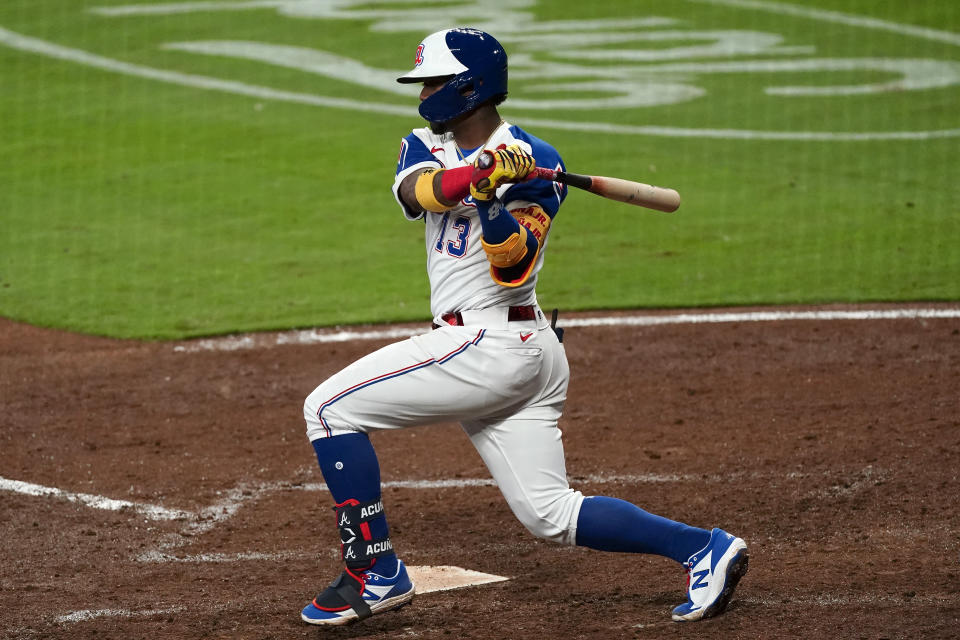 Atlanta Braves' Ronald Acuna Jr. (13) follows through on a double in the sixth inning of a baseball game against the Philadelphia Phillies, Friday, April 9, 2021, in Atlanta. (AP Photo/John Bazemore)