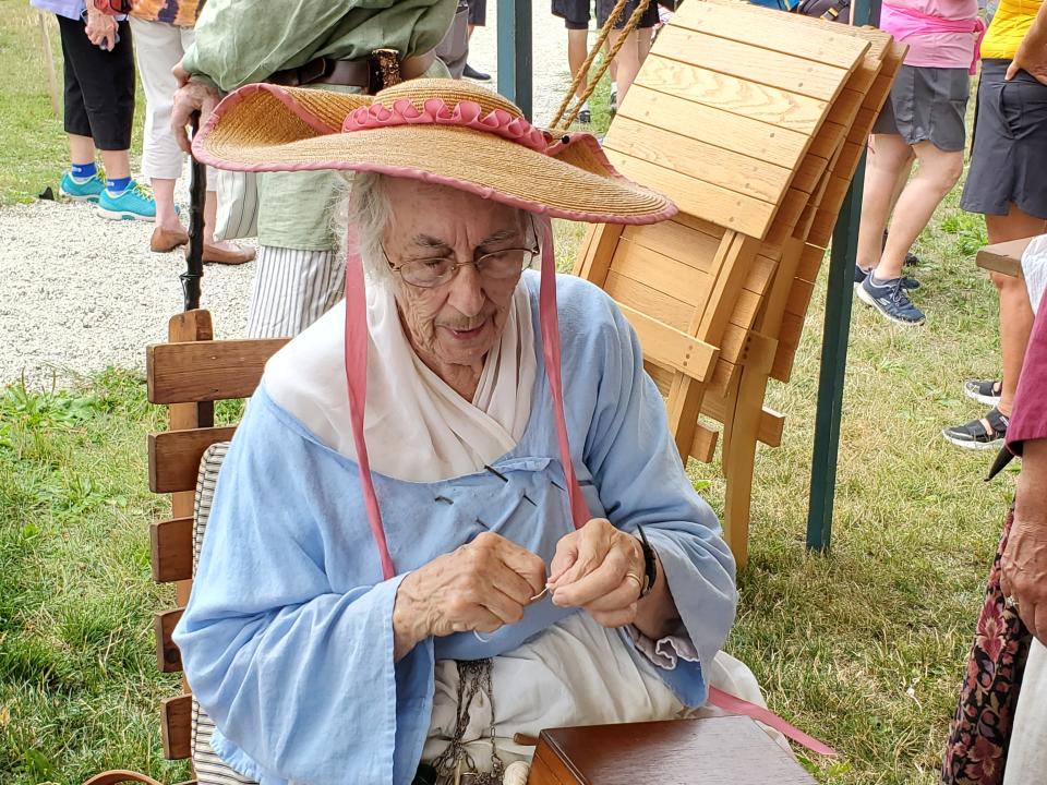 June White, a member of the First New Hampshire Regiment, sews thread buttons for the uniforms during the American Independence Festival in Exeter Saturday, June 16, 2022.