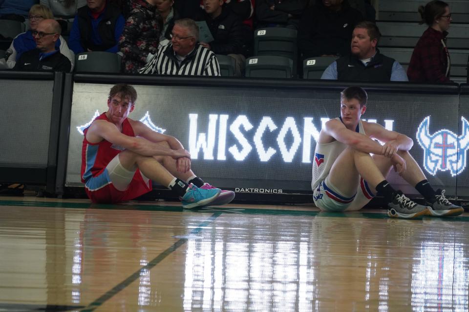 Bennett Basich (left) of Arrowhead and Kon Knueppel II (right) of Wisconsin Lutheran wait in front of the scorer’s table to check in during the Vikings’ 82-67 win over the Warhawks Friday at Wisconsin Lutheran College.