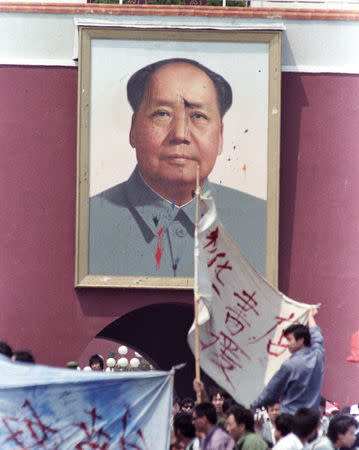 FILE PHOTO: Demonstrators in Tiananmen Square continue their protest in front of a defaced portrait of the late Chairman Mao in Beijing, China, May 23, 1989. REUTERS/Shunsuke Akatsuka/File Photo