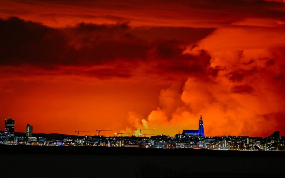 The skyline of Reykjavik can be seen against the backdrop of orange coloured sky