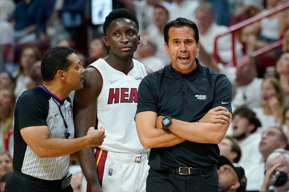 Miami Heat head coach Erik Spoelstra argues a call with referee Bill Kennedy during the first half of Game 2 of the NBA basketball Eastern Conference finals playoff series against the Boston Celtics, Thursday, May 19, 2022, in Miami. In between them is Miami Heat guard Victor Oladipo. (AP Photo/Lynne Sladky)