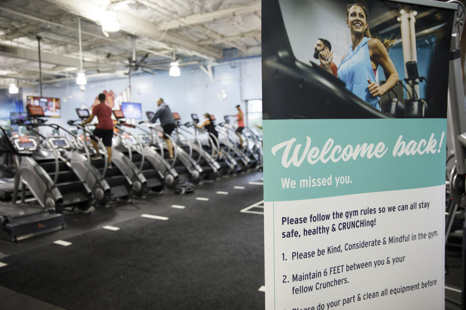 A "Welcome Back" sign is displayed as people exercise on stairmaster machines at a Crunch Fitness gym location in Burbank, California, U.S., on Tuesday, June 23, 2020. (Patrick T. Fallon/Bloomberg via Getty Images)