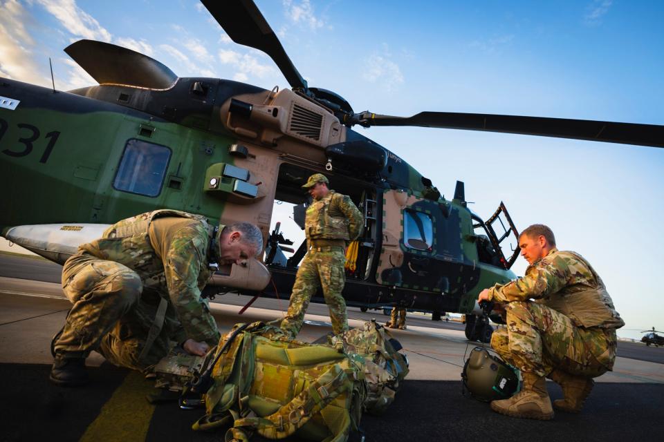 Aircrew from the Australian Army Aviation Corps and the U.S. Army preparing for a late afternoon flight on an Australian MRH90 during Exercise Talisman Sabre 2023 at RAAF Base Townsville, in Queensland. <em>COMMONWEALTH OF AUSTRALIA, DEPARTMENT OF DEFENSE</em>