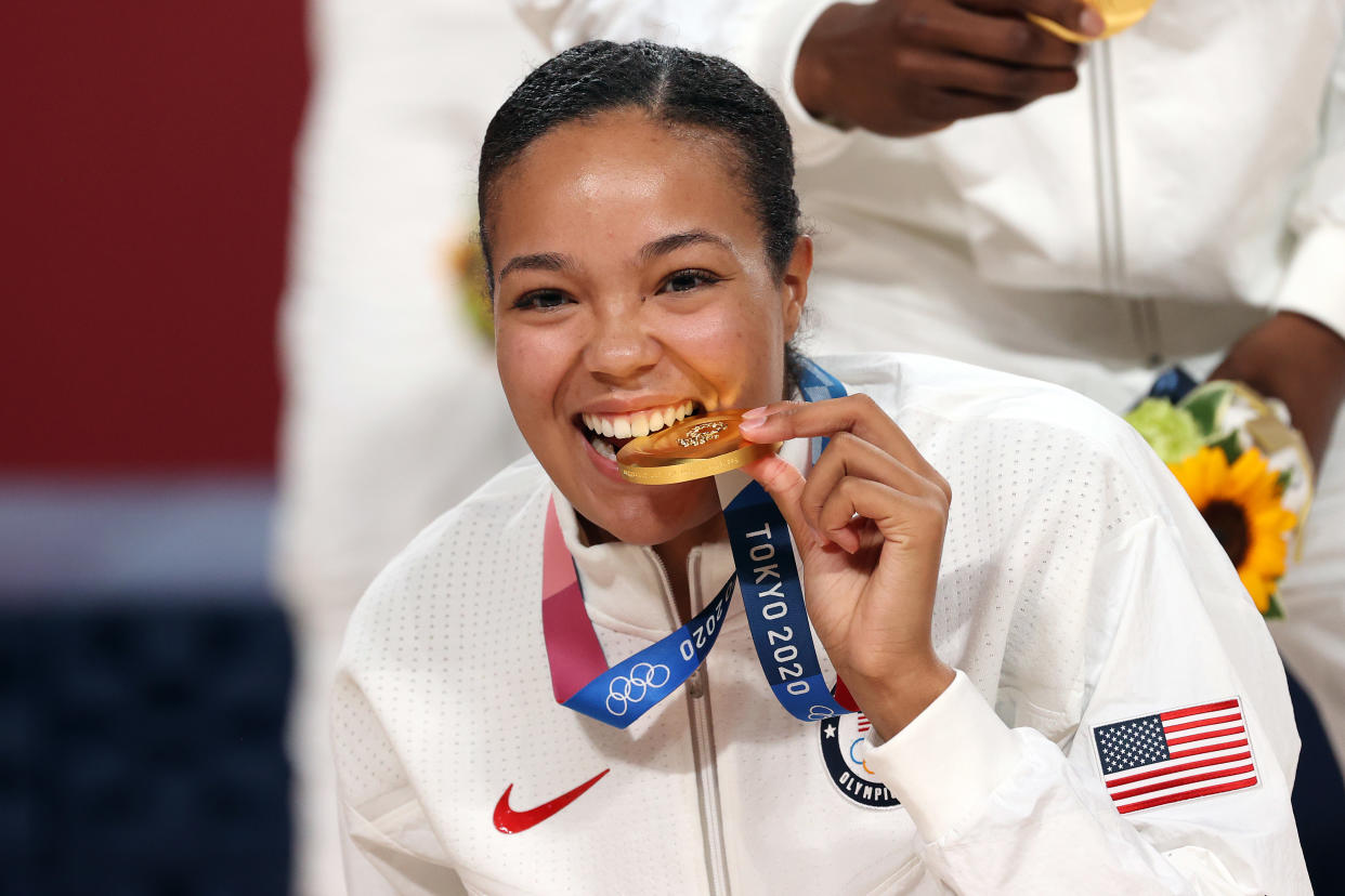 SAITAMA, JAPAN - AUGUST 08: Napheesa Collier #11 of Team United States bites her gold medal during the Women's Basketball medal ceremony on day sixteen of the 2020 Tokyo Olympic games at Saitama Super Arena on August 08, 2021 in Saitama, Japan. (Photo by Kevin C. Cox/Getty Images)