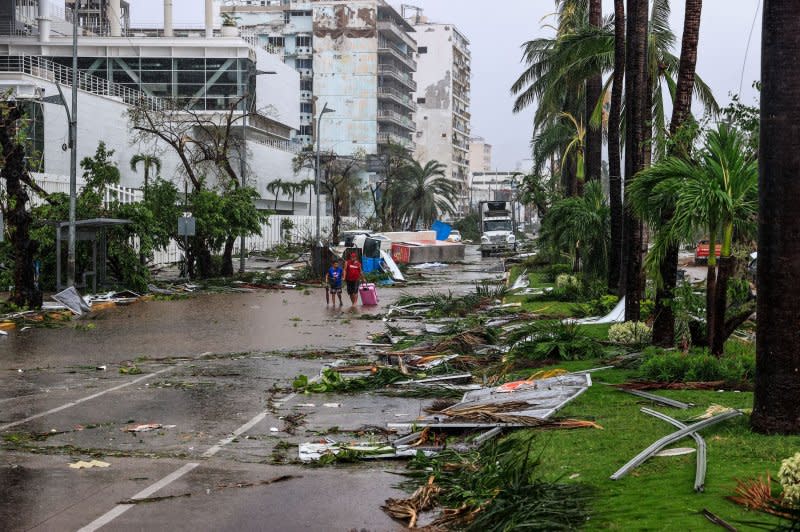 A couple walk through the debris of a street affected by Hurricane Otis in the beach resort of Acapulco, Mexico on Thursday. Photo by David Guzman/EPA-EFE