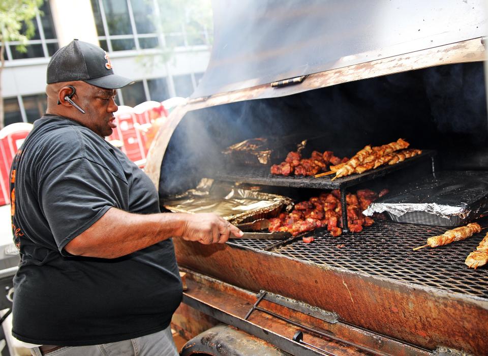 Frank Leachmon cooks pork at Leachmon Pit Stop BBQ during the 18th annual World Food and Music Festival last year.