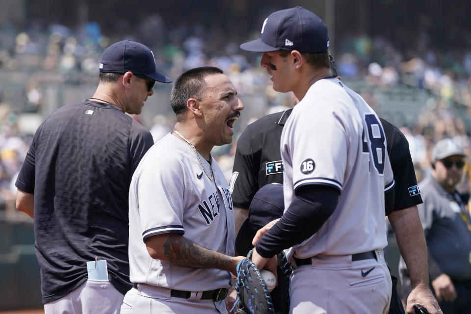 New York Yankees pitcher Nestor Cortes Jr., center, reacts to umpires next to first baseman Anthony Rizzo, right, during the second inning of a baseball game against the Oakland Athletics in Oakland, Calif., Saturday, Aug. 28, 2021. (AP Photo/Jeff Chiu)