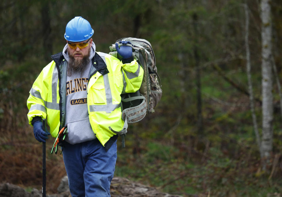 A worker wearing an Arlington Eagles sweatshirt gears up to enter the work area at the west site of the mudslide on Highway 530 near mile marker 37 on Friday, March 28, 2014. There were no major updates this morning to report, according to Snohomish District 21/22 Fire Chief Travis Hots, leaving the official count at 17 dead with 9 bodies yet to be recovered and 90 missing. Up to a half inch of rain is expected in the area Friday, which could hinder rescue and recovery efforts. "We've got a hard day ahead of us," Hots said. Cash donations are the best way to help at this point, according to Hots, who says they have enough volunteers. (AP Photo/Lindsey Wasson, Pool)