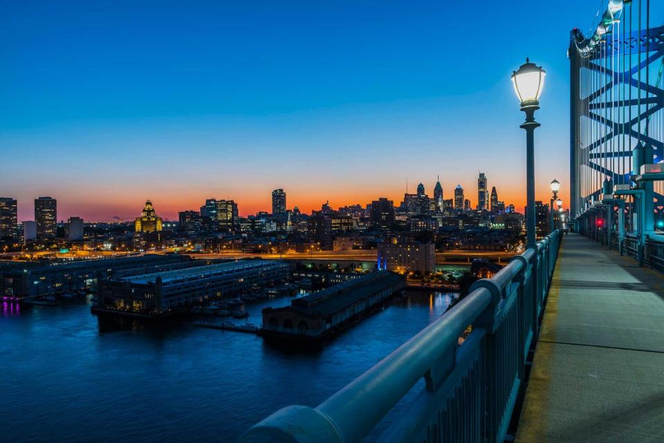 Philadelpia Downtown at sunset. The view from the Benjamin Franklin Bridge over the piers in Old City and Delaware River.