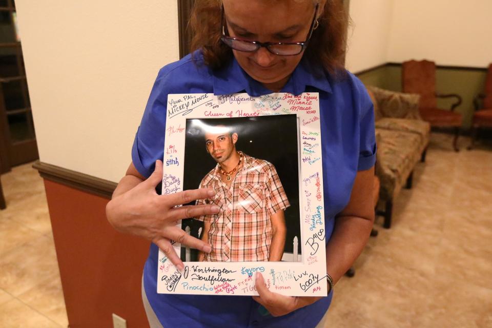 <p>Maria de los Angeles, the mother of Eric Ivan Ortiz-Rivera, one of the victims of the shooting at the Pulse night club in Orlando, displays a photo of her son at his wake in Kissimmee, Florida, on June 16, 2016. (Photo: Carlo Allegri/Reuters) </p>