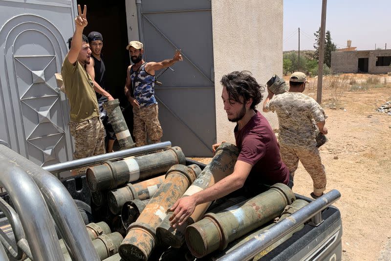 Fighters loyal to Libya's internationally recognised government carry confiscated weapons after regaining control over Tarhouna city