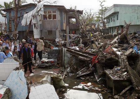 U.N. Secretary-General Ban Ki-moon (R) walks away after inspecting a devastated area of Fatima village at Tacloban city, central Philippines December 21, 2013, a month after super typhoon Haiyan hit the central Philippines. REUTERS/Romeo Ranoco
