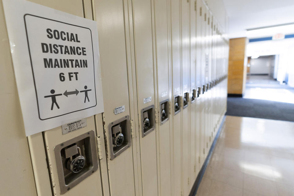 FILE - A sign that reads "Social Distance Maintain 6 ft" is posted on student lockers at a school in Baldwin, N.Y., on Aug. 28, 2020. Nationwide, students have been absent at record rates since schools reopened after COVID-forced closures. More than a quarter of students missed at least 10% of the 2021-22 school year. (AP Photo/Mark Lennihan, File)
