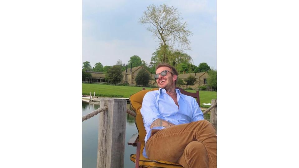 man posing in chair next to lake