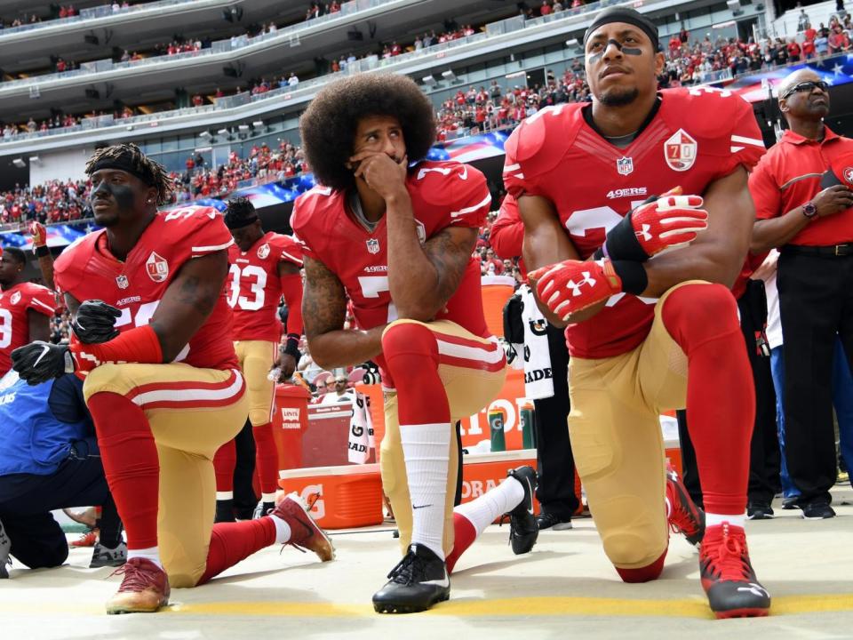 Eli Harold, Colin Kaepernick and Eric Reid of the San Francisco 49ers kneel during the anthem (Getty Images)