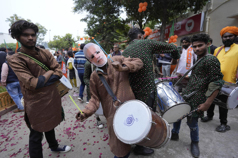 A man wearing a mask of Indian Prime Minister Narendra Modi plays a drum as supporters of India's ruling Bharatiya Janata Party, or BJP, celebrate early leads for the party in Rajasthan state elections in Jaipur, India, Sunday, Dec.3, 2023. Vote counting began Sunday in four Indian states in a test of strength for India's opposition pitted against the ruling party of Prime Minister Narendra Modi ahead of next year's crucial national vote. (AP Photo/Deepak Sharma)