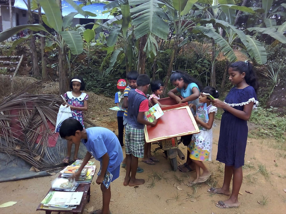 Children look to borrow books from a mobile library run on a motorbike by Mahinda Dasanayaka, in a village in Kegalle district, about 85 kilometers (53 miles) northeast of Sri Lanka's capital, Colombo, March 29, 20019. Having witnessed the hardships faced by children in rural areas whose villages have no library facilities, Dasanayaka got the idea for his library on wheels called “Book and Me." Dasanayaka, 32, works as a child protection officer for the government. On his off days, mostly during weekends, he rides his motorbike, which is fixed with a steel box to hold books, to rural villages and distributes the reading material to children free of charge. (AP Photo)