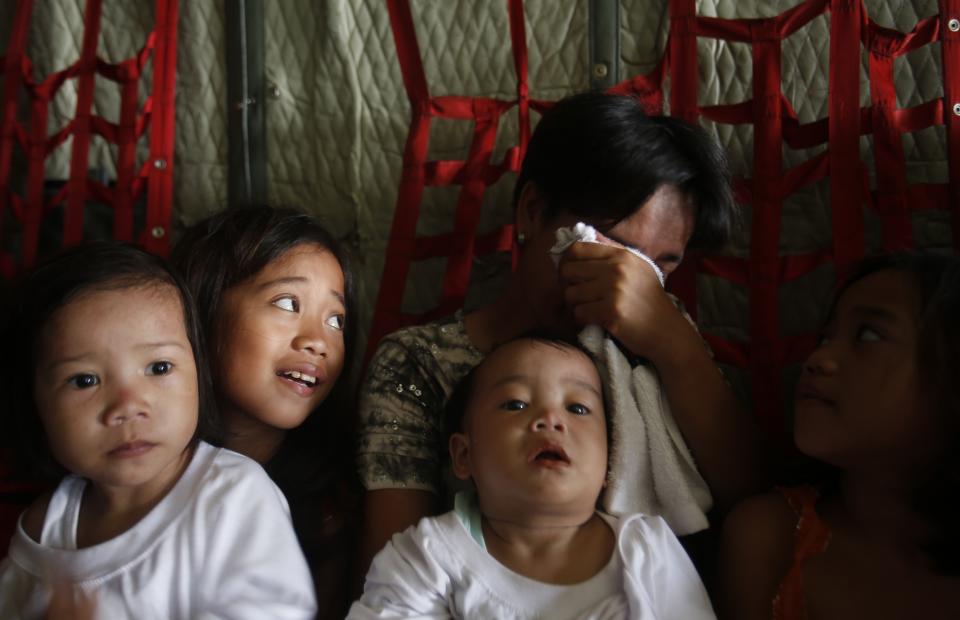 A woman cries as she and her children sit on board a C-130 military transport plane bound on a mercy flight to Manila, in the aftermath of the Super Typhoon Haiyan, from Tacloban city, in central Philippines, November 15, 2013. The death toll from the powerful typhoon that swept the central Philippines nearly doubled overnight, reaching 4,000, as helicopters from a U.S. aircraft carrier and other naval ships began flying food, water and medical teams to ravaged regions. REUTERS/Erik De Castro (PHILIPPINES - Tags: DISASTER ENVIRONMENT SOCIETY MILITARY TPX IMAGES OF THE DAY)