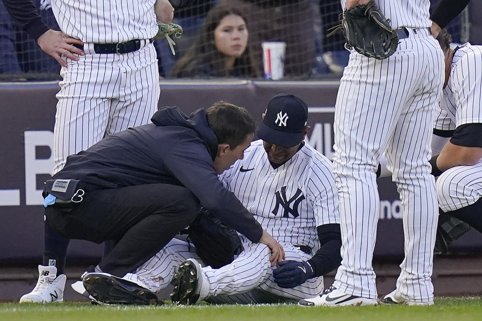 New York Yankees Aaron Hicks is checked by a trainer after colliding with Oswaldo Cabrera on a pop fly during the third inning of Game 5 of an American League Division baseball series against the Cleveland Guardians, Tuesday, Oct. 18, 2022, in New York. (AP Photo/Frank Franklin II)