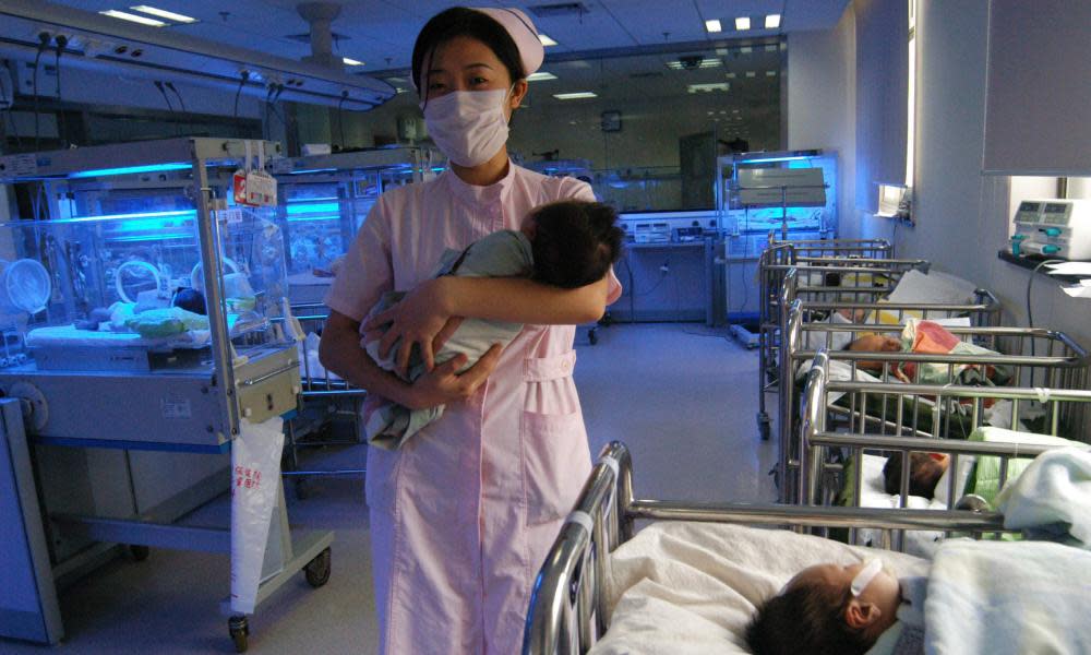 A nurse carries a baby at a maternity ward in Wuhan, Hubei province.