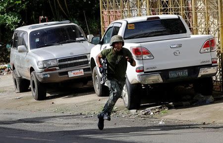 A Philippine Marine runs for cover near the stronghold of Maute group in Marawi City, southern Philippines May 30, 2017. REUTERS/Erik De Castro