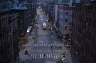 Bicyclists and a pedestrian pass through a quiet Manhattan street, Thursday, March 26, 2020, during the coronavirus pandemic in New York. The New York City immortalized in song and scene has been swapped out for the last few months with the virus version. In all the unknowing of what the future holds, there's faith in that other quintessential facet of New York City: that the city will adapt. (AP Photo/Mark Lennihan)