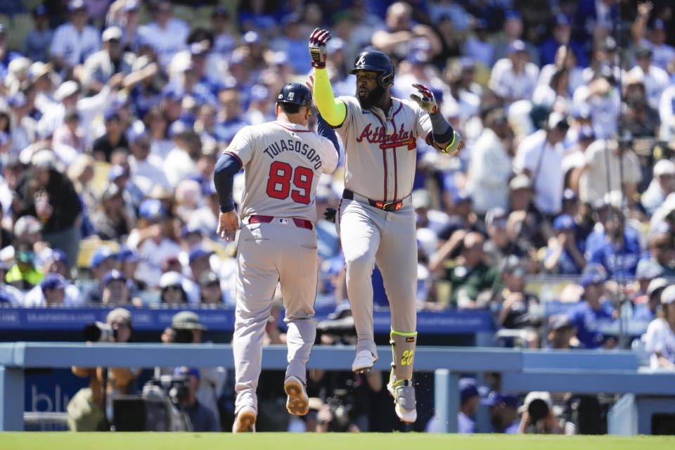 Atlanta Braves designated hitter Marcell Ozuna, right, celebrates with third base coach Matt Tuiasosopo (89) after hitting a home run during the seventh inning of a baseball game against the Los Angeles Dodgers in Los Angeles, Sunday, May 5, 2024. (AP Photo/Ashley Landis)