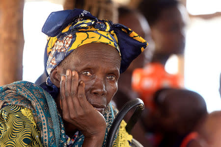 FILE PHOTO: A Congolese elderly woman, who migrated from Democratic Republic of Congo by fleeing on a boat across Lake Albert, waits to be registered by United Nations High Commission for Refugees (UNHCR) in Ntoroko, Uganda February 17, 2018. REUTERS/James Akena/File Photo