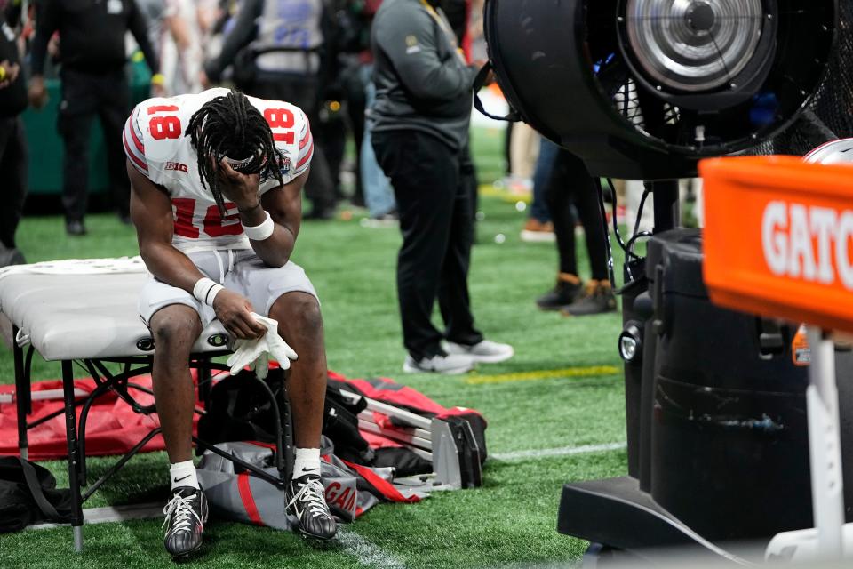 Dec 31, 2022; Atlanta, Georgia, USA; After being knocked out of the game in the third quarter, Ohio State Buckeyes wide receiver Marvin Harrison Jr. (18) holds his head on the bench following the Peach Bowl in the College Football Playoff semifinal at Mercedes-Benz Stadium. Georgia beat Ohio State 42-41. Mandatory Credit: Adam Cairns-The Columbus Dispatch