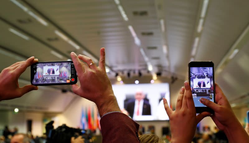 Journalists take pictures at the beginning of an OPEC and NON-OPEC meeting in Vienna