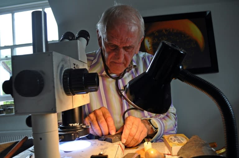 Micro-engraver Graham Short works on engraving a pin head in his studio in Birmingham, central England