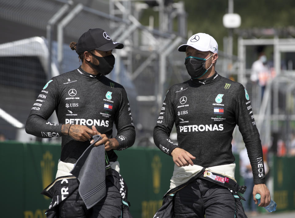 Mercedes driver Valtteri Bottas of Finland, right speaks with second placed Mercedes driver Lewis Hamilton of Britain after he clocked the fastest time during the qualifying session at the Red Bull Ring racetrack in Spielberg, Austria, Saturday, July 4, 2020. The Austrian Formula One Grand Prix will be held on Sunday. (Mark Thompson/Pool via AP)