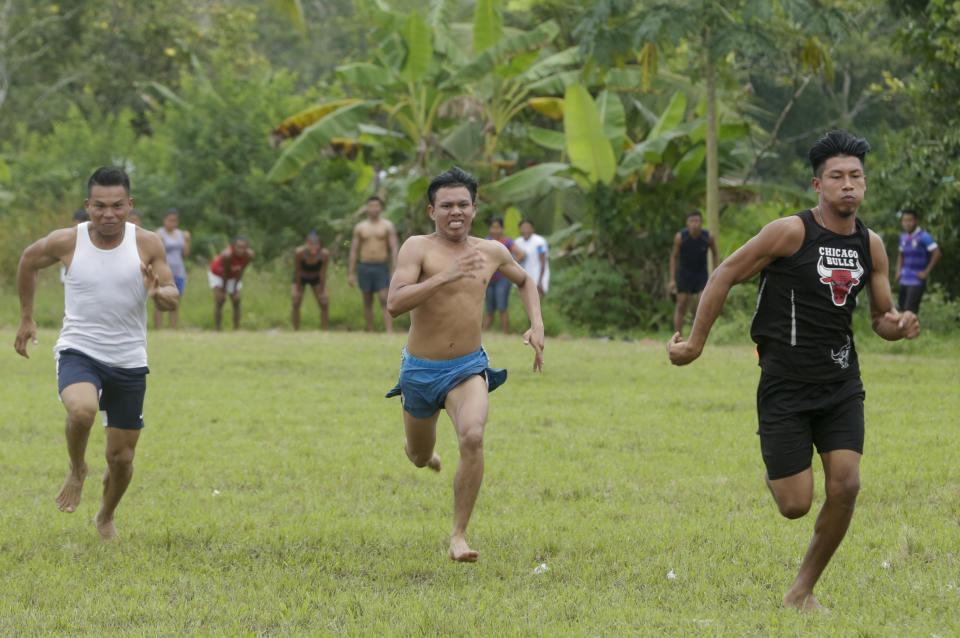 In this Nov. 26, 2018 photo, men run during 100 meters athletics competition of the second edition of the Panamanian indigenous games in Piriati, Panama. These games were held in the Embera town of Piriati, some 55 miles (90 kilometers) east of Panama City. (AP Photo/Arnulfo Franco)