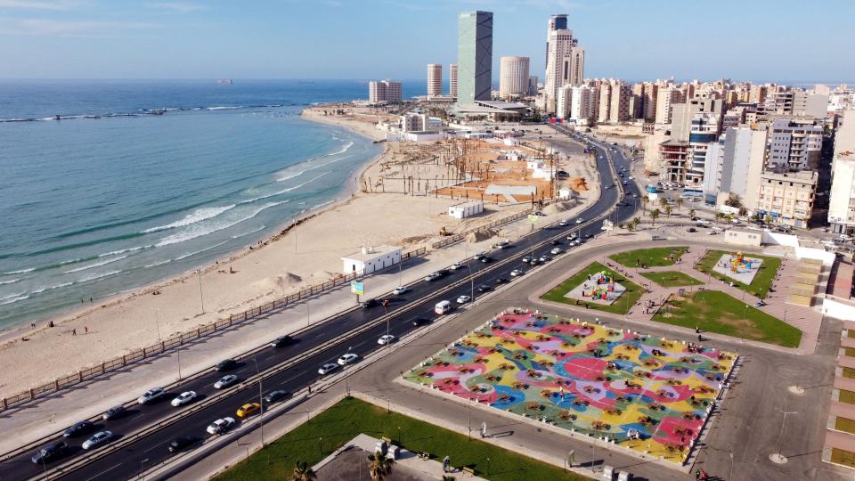 A photo of Tripoli, Libya including the city skyline, an oceanfront and a roadway.