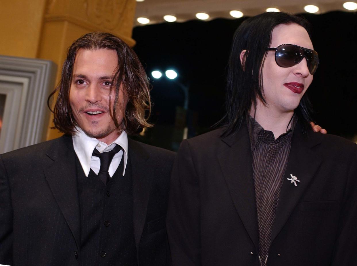 US actor Johnny Depp (L) greets his friend, rock singer Marilyn Manson, as he arrives at the premiere of his new film 