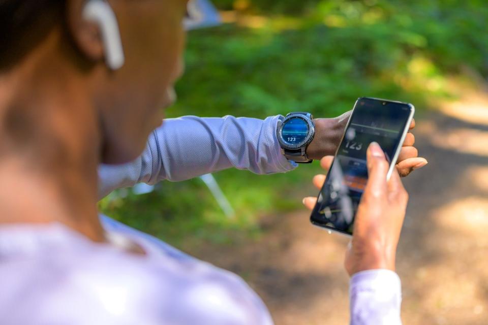 Lady syncing mobile tracker with smartphone