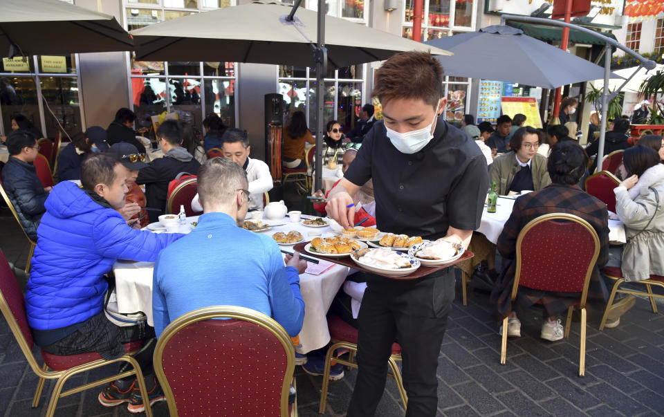 People enjoying outdoor restaurants in Chinatown, London Saturday, April 17, 2021. (AP Photo/Rui Vieira)