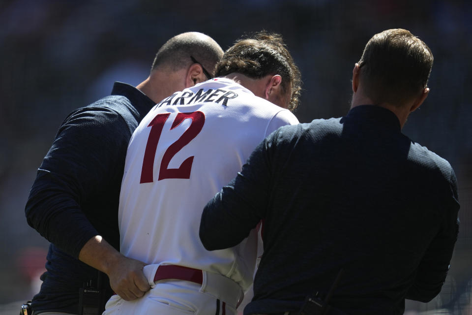 Minnesota Twins' Kyle Farmer exits the game with trainers after being hit in the head by a pitch during the fourth inning of a baseball game against the Chicago White Sox, Wednesday, April 12, 2023, in Minneapolis. (AP Photo/Abbie Parr)