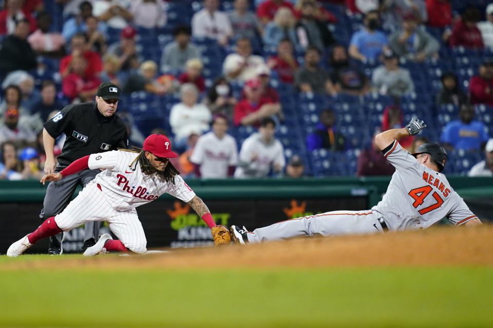 Philadelphia Phillies third baseman Freddy Galvis, left, tags out Baltimore Orioles' John Means at third after Means tried to advance on a passed ball during the seventh inning of an interleague baseball game, Monday, Sept. 20, 2021, in Philadelphia. (AP Photo/Matt Slocum)