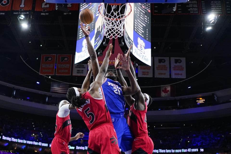 Philadelphia 76ers' Joel Embiid, center, got up for a shot against Toronto Raptors' Chris Boucher, from left, Precious Achiuwa and Pascal Siakam during the first half of Game 5 in an NBA basketball first-round playoff series, Monday, April 25, 2022, in Philadelphia. (AP Photo/Matt Slocum)