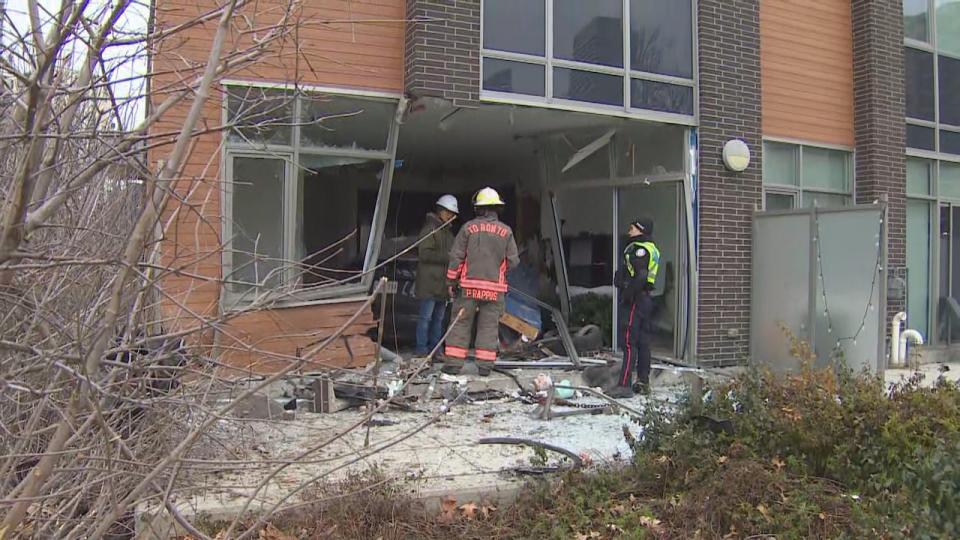 Officials survey the damage done at a North York townhouse Friday morning after a car crashed into it late Thursday night.   (Keith Burgess/CBC - image credit)