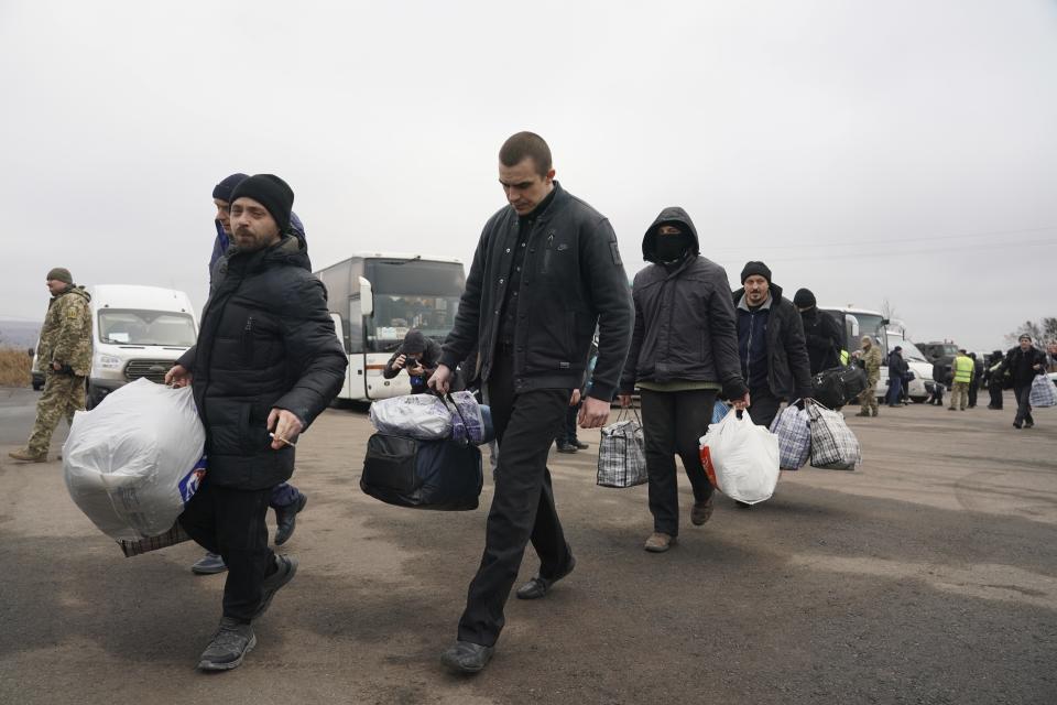 Ukrainian war prisoners walk after being released after a prisoner exchange, near Odradivka, eastern Ukraine, Sunday, Dec. 29, 2019. Ukrainian forces and Russia-backed rebels in eastern Ukraine have begun exchanging prisoners in a move aimed at ending their five-year-long war. The move is part of an agreement brokered earlier this month at a summit of the leaders of Ukraine, Russia, Germany and France. (AP Photo/Evgeniy Maloletka)