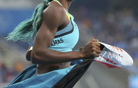 2016 Rio Olympics - Athletics - Final - Women's 400m Final - Olympic Stadium - Rio de Janeiro, Brazil - 15/08/2016. Shaunae Miller (BAH) of Bahamas holds her shoes in her hands as she celebrates after winning the gold medal. REUTERS/Sergio Moraes