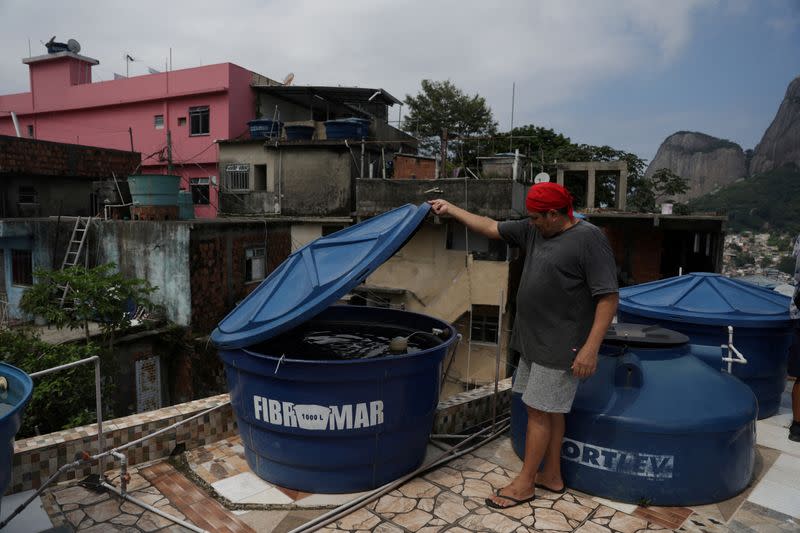 FILE PHOTO: Jurandi Perera, a restaurant owner, checks his water container at his home in the Rocinha favela in Rio de Janeiro