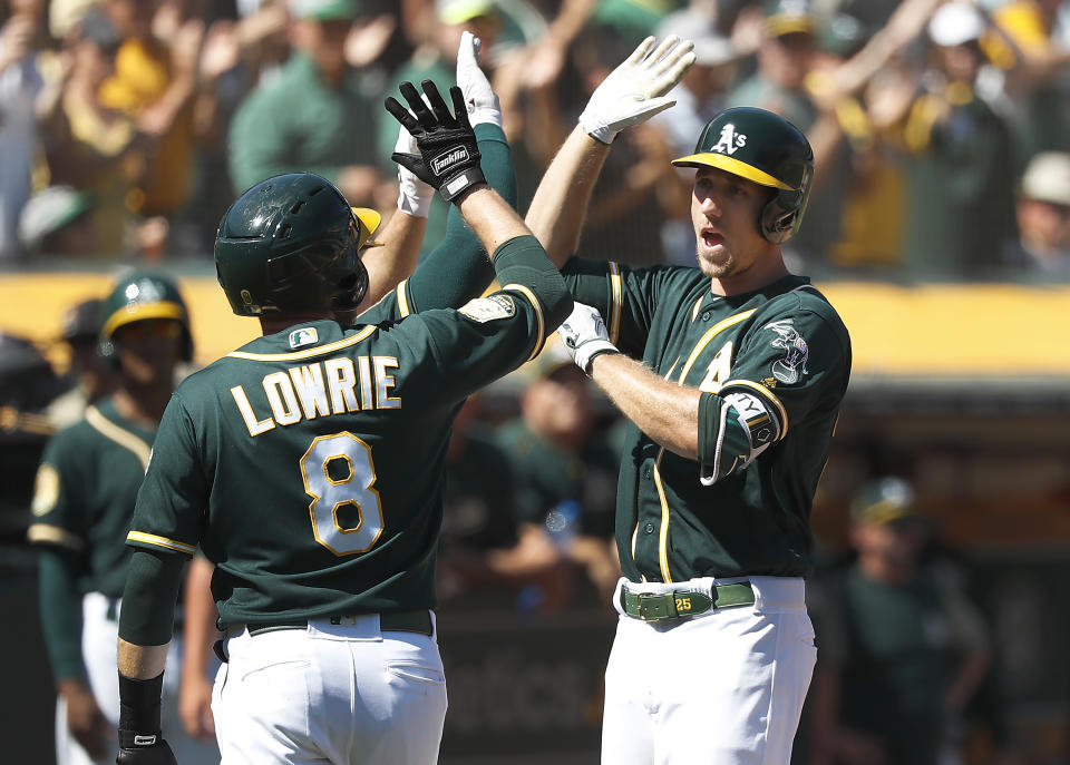 Oakland Athletics' Stephen Piscotty, right, is congratulated by teammate Jed Lowrie (8) after hitting a three-run home run against the Oakland Athletics during the third inning in a baseball game in Oakland, Calif., Thursday, Sept. 20, 2018. (AP Photo/Tony Avelar)