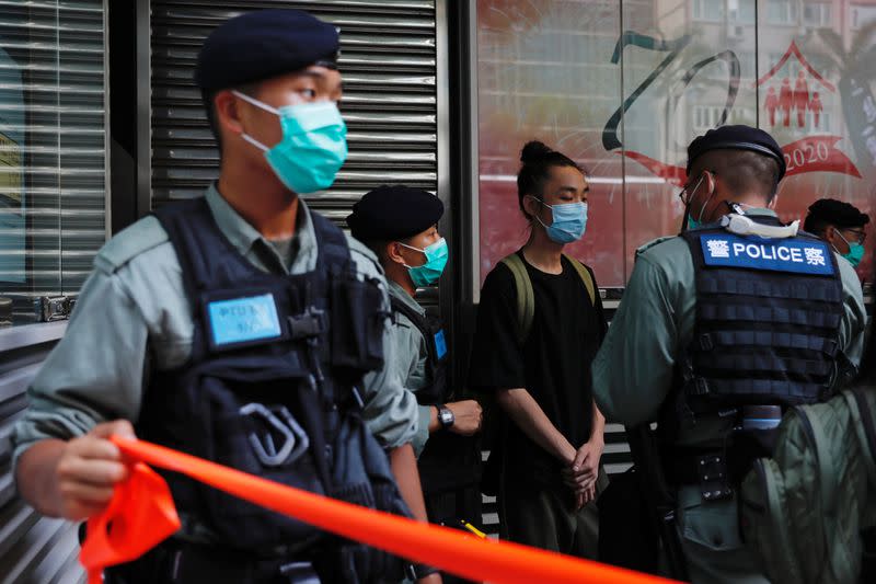 Police search a pro-democracy protester during a demonstration on the anniversary of Hong Kong's handover to China in Hong Kong